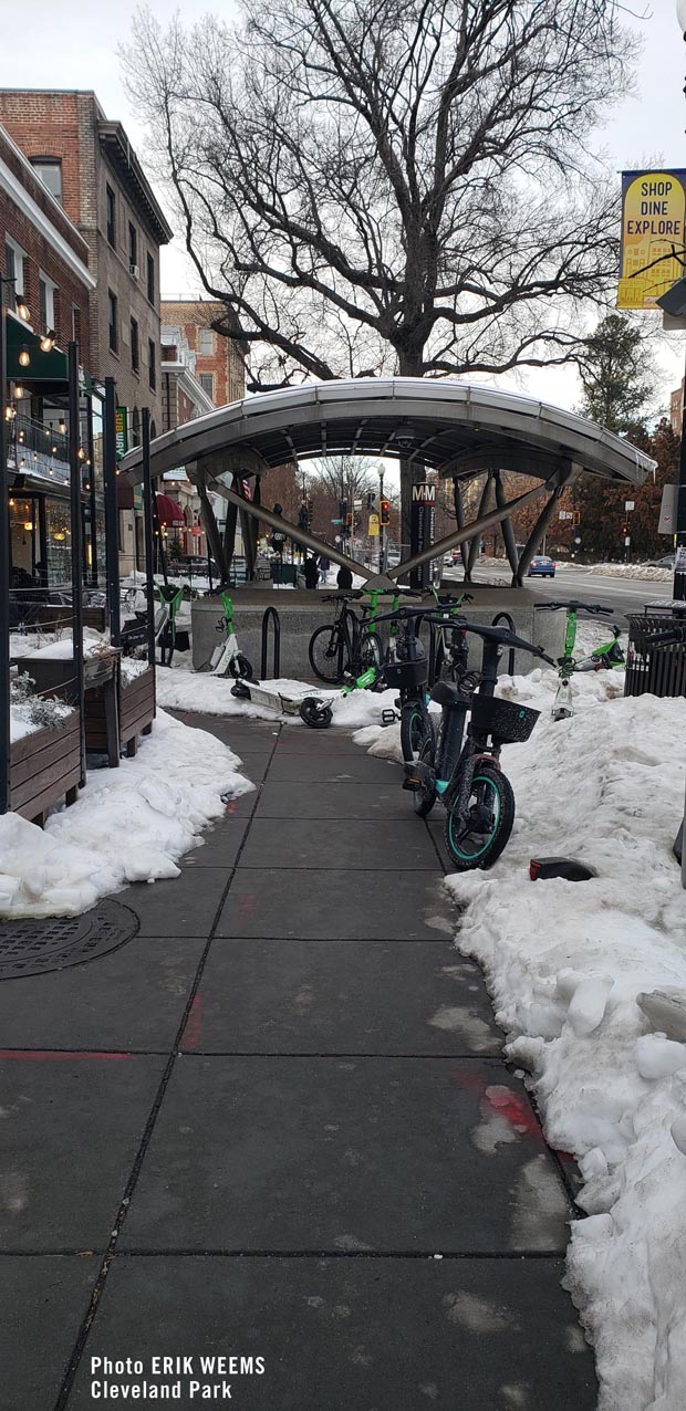 Cleveland Park Metro in the snow with e scooters